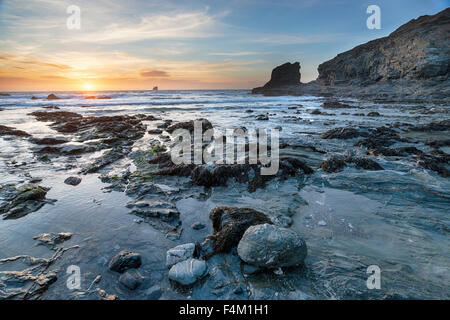 Tramonto a Trevellas Coombe, una piccola caletta rocciosa a Sant Agnese in Cornovaglia Foto Stock