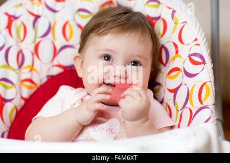 Bambino con anello di dentizione seduto in culla Foto Stock