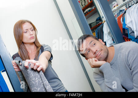 Annoiato uomo in attesa di sua moglie in un negozio Foto Stock