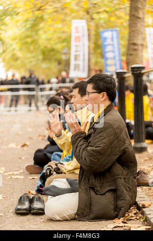 Londra, Regno Unito. Il 20 ottobre 2015. I membri della setta Falun Gong meditare in opposizione come la folla di attendere per vedere il presidente cinese Xi Jinping, viaggio verso il Mall in rotta verso Buckingham Palace, durante la sua visita di Stato nel Regno Unito. Credito: Stephen Chung / Alamy Live News Foto Stock