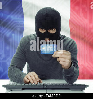 Di carnagione scura hacker con la carta di credito in mano e bandiera su sfondo - Francia Foto Stock