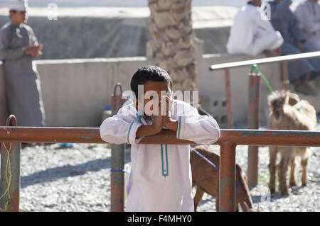 Un ragazzo triste a Nizwa mercato. L'ex capitale di Oman Nizwa moderno è famosa per la sua vivace suq e mercato del bestiame. Foto Stock