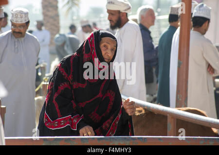 Vecchia donna su Nizwa in abito tradizionale sul giorno di mercato. Nizwah è famosa per la sua vivace souq e mercato del bestiame. Foto Stock