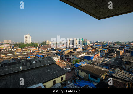 Birds Eye view al di fuori di un edificio alto e verso il basso per i tetti di dharavi slum, la seconda più grande delle baraccopoli in Asia Foto Stock