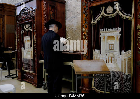 Un Ebreo adoratore pregando accanto alla Torah Arca armadio che contiene la Torah ebraica scorre decorata con una figura che illustra il biblico tempio ebraico all'interno di uomini della sezione di Wilson's Arch presso il Muro Occidentale composto nella città vecchia. Gerusalemme Est, Israele Foto Stock