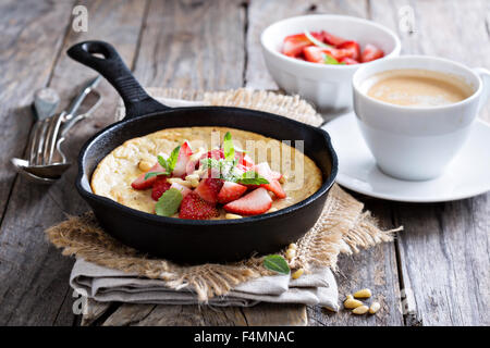 Pancake cotti al forno in ghisa padella con fragole fresche e pinoli Foto Stock