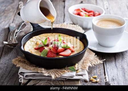 Pancake cotti al forno in ghisa padella con fragole fresche e pinoli Foto Stock