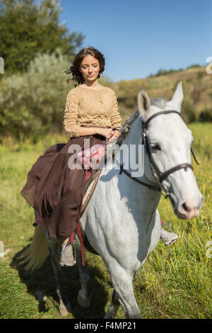 Bella ragazza in sella ad un cavallo bianco Foto Stock