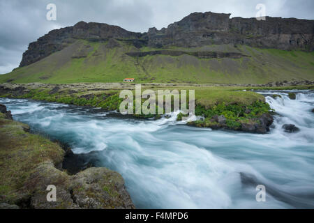 Scogliere e agriturismo accanto al fiume Odulbruara, Brunasandur, Sudhurland, Islanda. Foto Stock