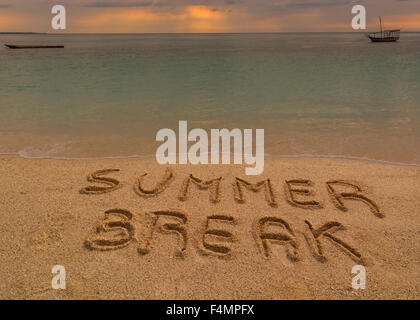 Nella foto una spiaggia al tramonto con le parole sulla sabbia 'Summer pausa'. Foto Stock