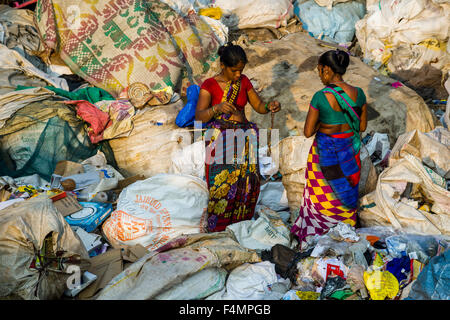 Due donne in sari colorati sono di smistamento di garbage. circa 10.000 manodopera stanno lavorando in 800 piccole aziende, principalmente in un abito Foto Stock