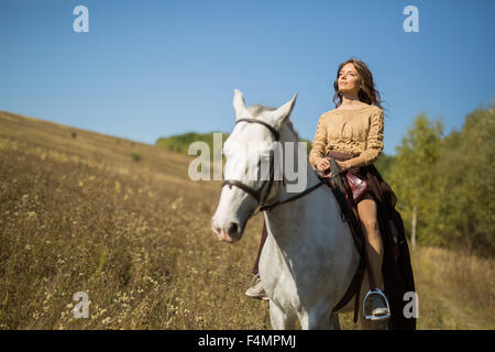 Bella ragazza in sella ad un cavallo bianco Foto Stock