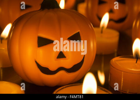 Piccolo giocattolo di Halloween zucche circondato da orange tealight candele Foto Stock