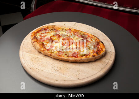 Pizza su una tavola di legno con salsicce calde Foto Stock