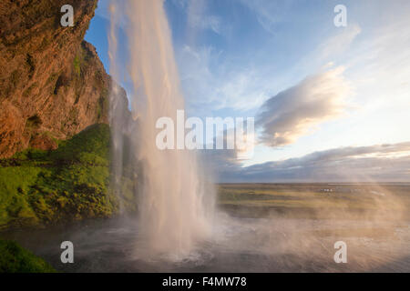 Cascata Seljalandsfoss immergendosi 60m dalla scogliera sopra, Sudhurland, Islanda. Foto Stock