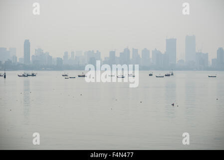 Lo skyline del borgo worli si vede attraverso il mahim bay con alcune barche da pesca nella foschia mattutina Foto Stock