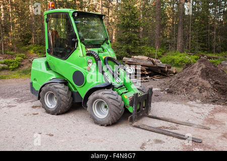 Green piccolo carrello elevatore sorge su un area di registrazione nella foresta Foto Stock