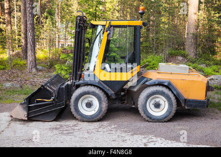 Carrello giallo con benna generale sorge su un area di registrazione Foto Stock