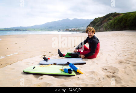 Spagna, Asturias, Colunga, body board rider preparazione sulla spiaggia Foto Stock