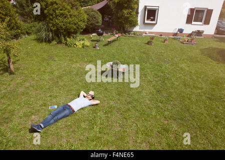 Uomo disteso sul prato rilassante da giardinaggio Foto Stock