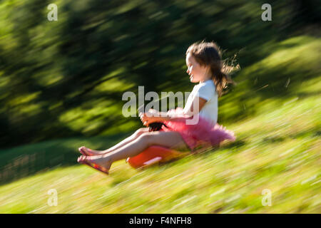 Bambina la guida di Bob in discesa su un prato Foto Stock