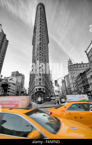 Colore selettivo immagine dell'iconico Flatiron Building con due taxi gialli, Manhattan New York STATI UNITI D'AMERICA Foto Stock