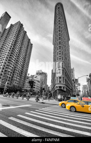 Colore selettivo immagine dell'iconico Flatiron Building con due taxi gialli, Manhattan New York STATI UNITI D'AMERICA Foto Stock