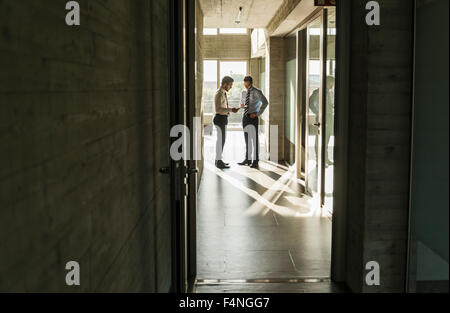 Due imprenditori in piedi nella sala di office Foto Stock