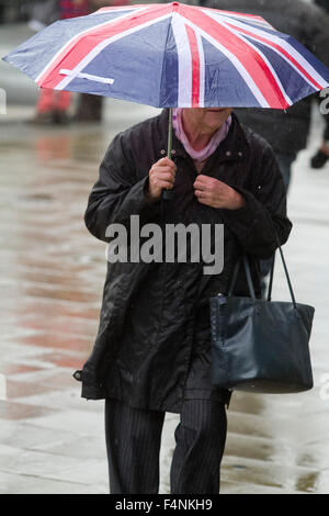 Il torneo di Wimbledon, Londra, Regno Unito. Xxi oct, 2015. Pedoni rifugio con ombrelloni a Wimbledon centro città come il tempo piovoso restituisce Credito: amer ghazzal/Alamy Live News Foto Stock