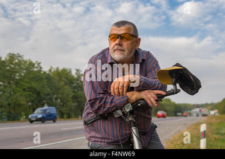 Outdoor ritratto di un barbuto uomo senior con noleggio biciclette Foto Stock