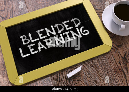 Blended Learning manoscritte da bianco gesso su una lavagna. Composizione con piccolo giallo Chalkboard e tazza di caffè. Top vie Foto Stock