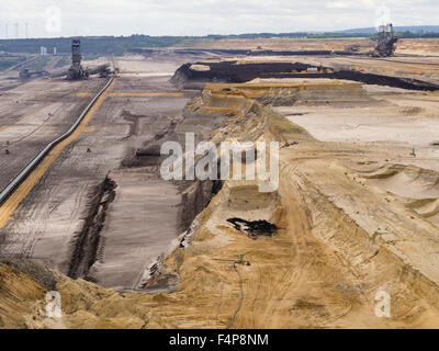 Benna-escavatori gommati nel paesaggio cratered della superficie campo minerario a Garzweiler, più grande della Germania a cielo aperto pit. Foto Stock