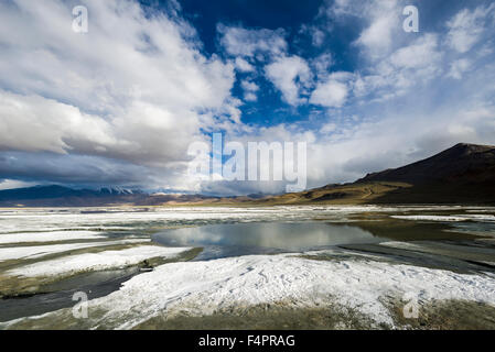 Strati di sale, paesaggio arido, cielo blu e nuvole scure a tso kar, una fluttuazione di Salt Lake, situato ad un altitudine di 4.530 Foto Stock