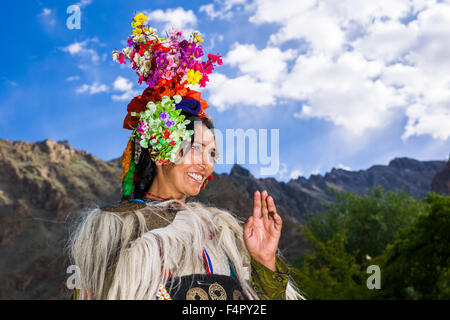 Una donna della tribù brokpa, una gara arien, nel suo abito tradizionale con una disposizione del fiore portato sulla testa Foto Stock