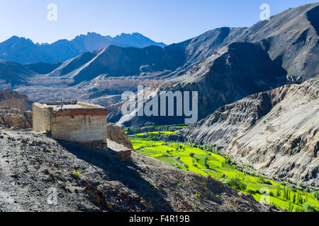 Paesaggio arido, una piccola casa, campi verdi e blu cielo al villaggio di lamayuru, il moonlands nella distanza Foto Stock