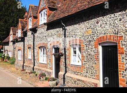 Piuttosto in mattoni e pietra focaia cottages con finestre dormer lungo un villaggio street, Hambledon, Oxfordshire, Inghilterra, Regno Unito, Europa occidentale. Foto Stock