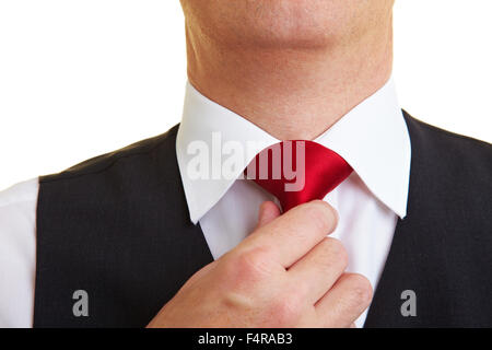 Imprenditore controllando il suo nodo di cravatta con la mano Foto Stock