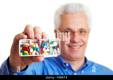 Senior Citizen tenendo un tedesco porta pillole Foto Stock