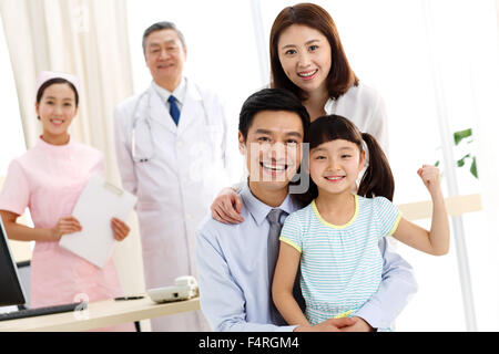 Una famiglia di tre persone e lavoratori medici Foto Stock