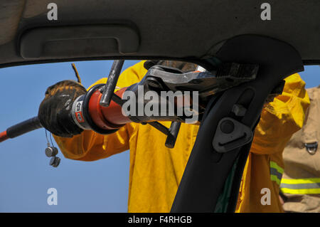 Vigili del fuoco utilizza strumenti di potenza al salvataggio dei passeggeri rimasti intrappolati da un auto Foto Stock