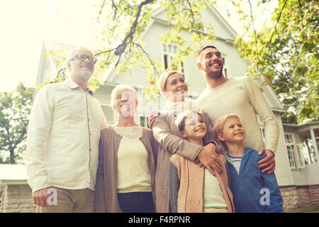 La famiglia felice davanti la casa all'aperto Foto Stock