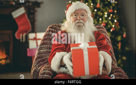 Babbo Natale che offre un regalo rossa Foto Stock