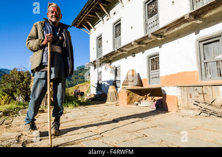 Agricoltore in piedi nella parte anteriore della sua casa bianca Foto Stock