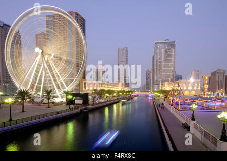 Vista serale dell'occhio degli Emirati ruota panoramica Ferris e Al Qasba entertainment district in Sharjah Emirati Arabi Uniti Foto Stock