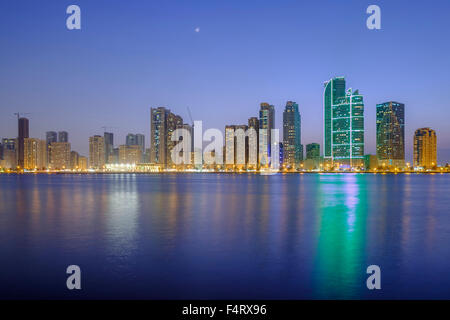 Sera vista sullo skyline di alto e moderno appartamento edifici sulla Corniche in Sharjah Emirati Arabi Uniti Foto Stock