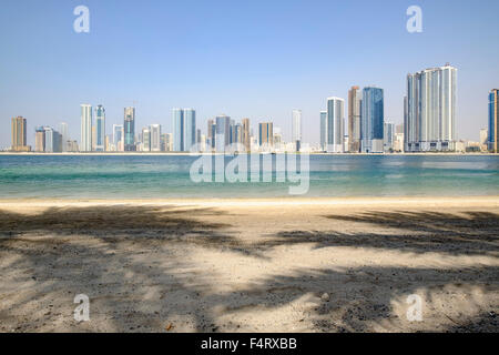 Il giorno dello skyline di spiaggia e alto e moderno appartamento edifici lungo la corniche in Sharjah Emirati Arabi Uniti Foto Stock