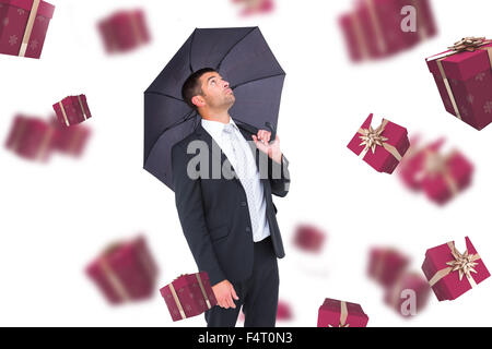 Immagine composita di imprenditore il ricovero sotto ombrellone nero Foto Stock