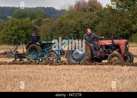 L'agricoltore al volante della sua 1958 Massey Ferguson 35 trattore con aratro Ransomes competere nel Nord Est Hants agricolo di un Foto Stock