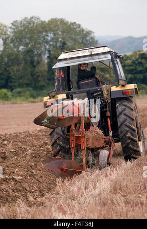 L'agricoltore al volante della sua 1983 trattore Marshall con Kverneland aratro competere nel Nord Est Hants agricola... Foto Stock