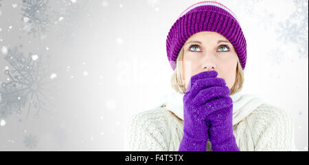 Immagine composita di congelamento del giovane donna indossa guanti guardando verso l'alto Foto Stock